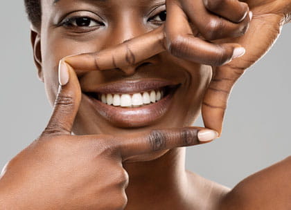 Woman framing her smile in her hands